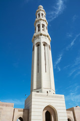 Fototapeta premium Minaret of the Muscat Grand Mosque silhouetted in the blue sky