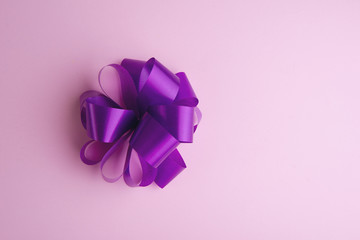 Beautiful purple bow isolated on pink background