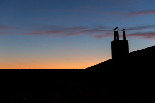 Dramatic sunset sky with chimney silhouette
