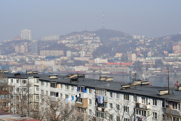 Russia. Winter Vladivostok in a haze. In the foreground street Okatovaya