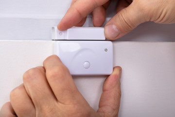 Person Hand Fixing Security System Door Sensor