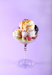 Assorted ice cream in glass over purple background