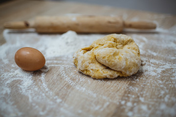 The girl prepares the dough for homemade noodles. On the table there is everything you need.