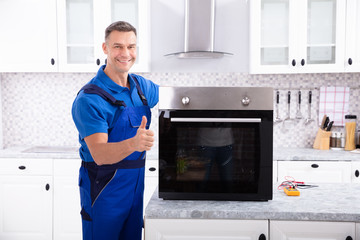 Male Technician Repairing Oven