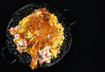 spice roasted whole baby chicken with flavored rice in a serving dish