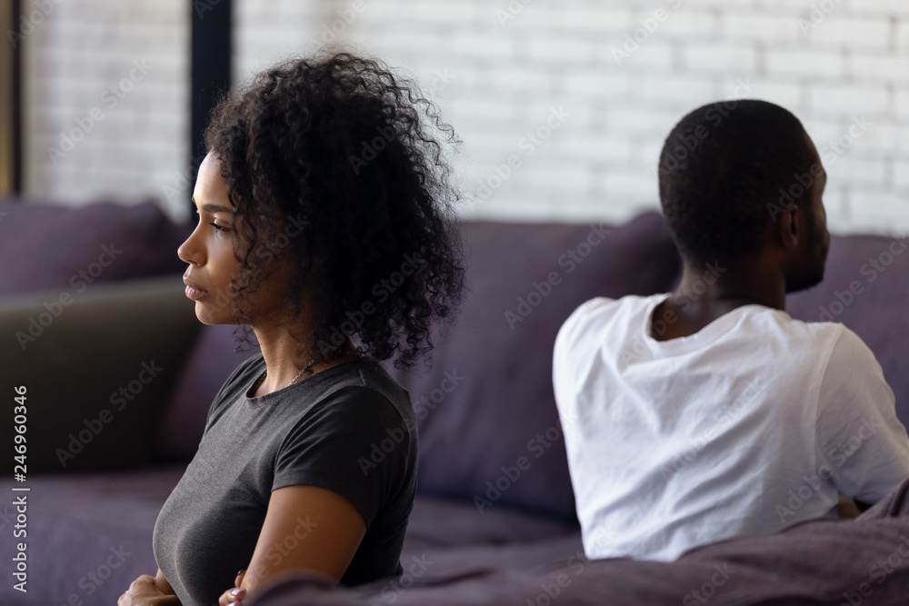 Wall mural Sad unhappy african wife avoiding talk ignoring husband after couple fight feels indifferent offended, upset frustrated black girlfriend tired of problems, thinking of divorce with selfish boyfriend