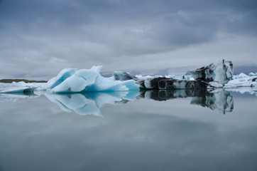 Fototapeta na wymiar Blue and white ice with black volcanic ashes on Joekulsarlon glacier lagoon, Iceland