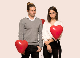 Fototapeta na wymiar Couple in valentine day with sad and depressed expression over isolated background