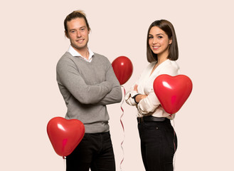 Couple in valentine day with arms crossed and looking forward over isolated background