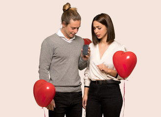 Couple in valentine day with troubled holding broken smartphone over isolated background