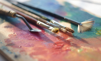 Artistic tools to create a picture lie on the palette with oil paint