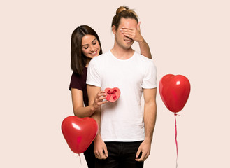 Fototapeta na wymiar Couple in valentine day holding gift box over isolated background