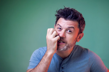 People and emotions - a portrait of nervous man bit his nails