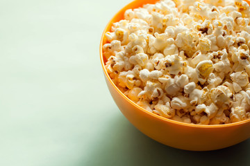 Fototapeta na wymiar An orange bowl with popcorn isolated