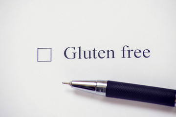 Checklist box with words gluten free and pen on white paper. Check form concept