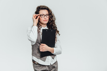 Happy beautiful young business woman standing. Holding clipboard over white background .