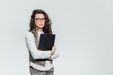 Fototapeta premium Happy beautiful young business woman standing. Holding clipboard over white background .