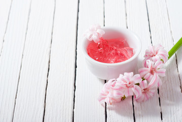 beauty and cosmetic creams with pink flowers on white wood