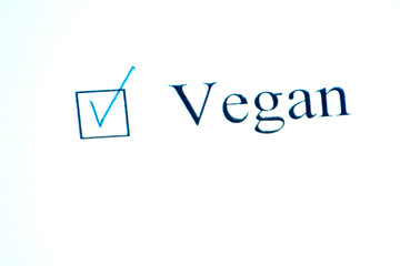 Checklist with a word Vegan on white paper. Checkbox concept.