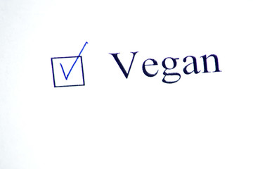 Checklist with a word Vegan on white paper. Checkbox concept.