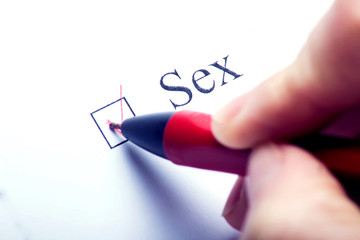 Sex - checkbox with a cross on white paper with pen. Checklist concept.