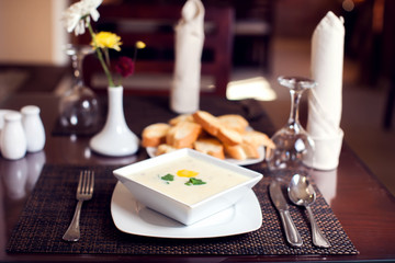 Cream soup and bread croutons on the table in cafe. Food concept