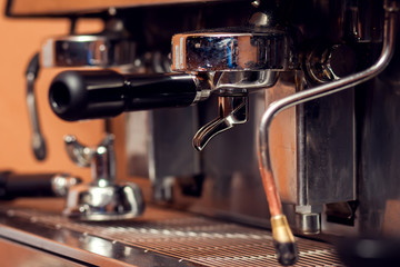 Close up details of brewing machinery pouring and preparing espresso. Cafe shop details. Food and cafe concept