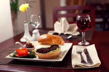 Large tasty burger with French fries in a cafe on a white plate. Food concept