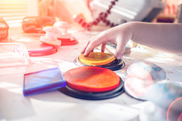 boy is having fun while playing with stamps and tempera paints on wooden work desk producting multicolor creations