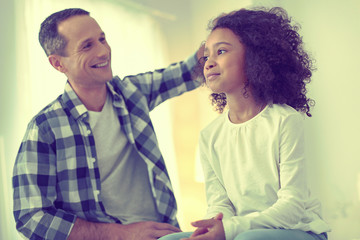 Playful father excitedly feeling his adopted daughters fluffy hair.