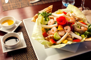 Sea food salad with sauces on white plate. Food and restaurant concept