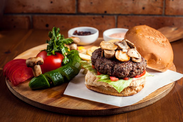 Large tasty burger with mushrooms with French fries. Food concept
