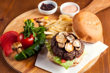 Large tasty burger with mushrooms with French fries. Food concept
