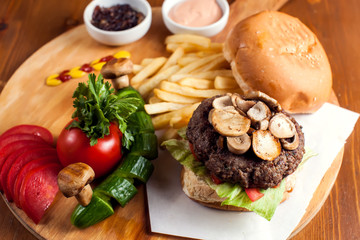 Large tasty burger with mushrooms with French fries. Food concept