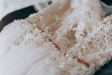 Bride in pink dress. Pink luxury dress is getting ready for wedding. Morning preparations
