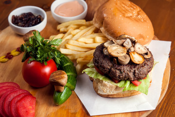 Large tasty burger with mushrooms with French fries. Food concept