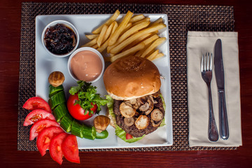 Large tasty burger with mushrooms with French fries. Food concept