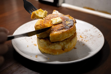 enjoy eating with forkFluffy Japan souffle pancakes, hotcakes with honey syrup and butter light concrete