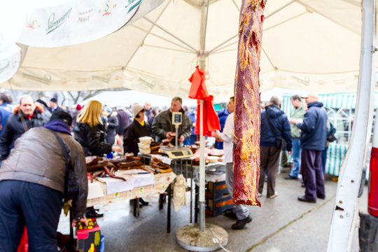 People are buying smoked meat on stall, street market