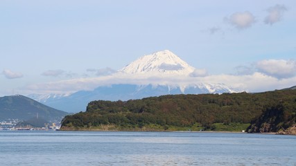 Koryaksky volcano rises above the coastline of the Kamchatka Peninsula. Koryaksky or Koryakskaya Sopka is an active volcano on the Kamchatka Peninsula in the Russian Far East.