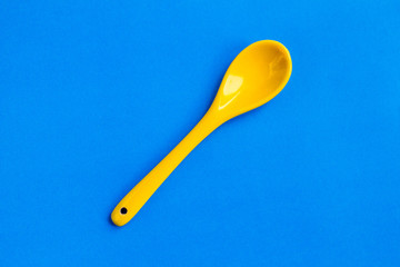 small yellow spoon on blue background
