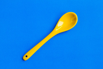 small yellow spoon on blue background