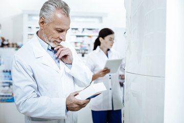 Obraz premium Two drugstore workers in white coat looking busy