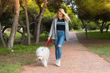 Young girl walking with her dog in a park