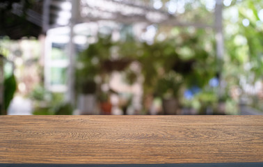 Fototapeta premium Empty dark wooden table in front of abstract blurred bokeh background of restaurant . can be used for display or montage your products.Mock up for space.