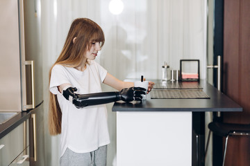 adaaptation, young girl learning to hold a cup of tea. close up side view photo