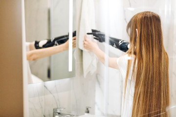 disabled girl touching the white towel in the bathroom. close up back view photo. copy space, girl wipes her hands after washing them