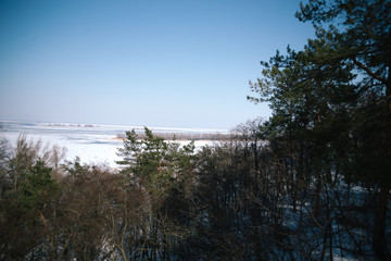 A spring sunny day in a snowy park