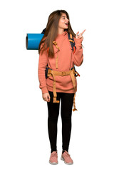 Full-length shot of Hiker girl pointing finger to the side in lateral position on isolated white background