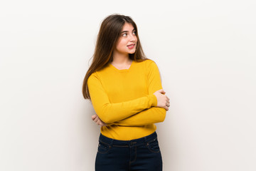 Young woman with yellow sweater with confuse face expression while bites lip